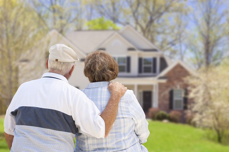 Senior couple looking back at their house